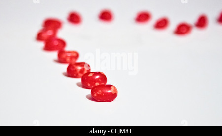 Roten herzförmigen Bonbons gegen weiß Stockfoto