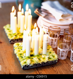 Tabelle Kunst sehr wenig ist erforderlich, um die Gäste, ein paar grüne Blätter, beeindrucken beleuchtet Kerzen und knackigen weißen Blüten, kleine schöne Stockfoto