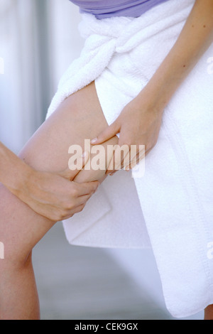 Zugeschnittenen Schuss von Weibchen tragen lila Top mit weißen Tuch eingewickelt Runde Taille kneifen Oberschenkel mit beiden Händen Stockfoto