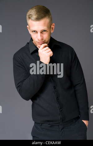 Porträt eines jungen Mannes der Handosme Haltung mit schelmischen Lächeln zu denken. Stockfoto