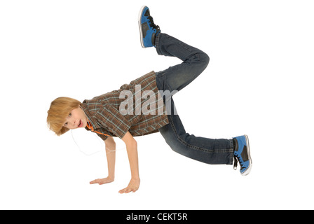 Elfjähriger Junge tragen Kopfhörer, MP3-Player anhören und tanzen auf dem Boden. Stockfoto