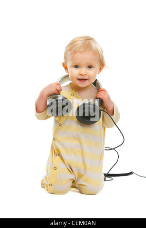 Glückliches Baby mit Kopfhörern auf Exemplar isoliert auf weiss Stockfoto