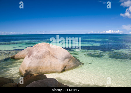 Anse Bois De Rose, Praslin, Seychellen. Blick über das klare Wasser des Indischen Ozeans, Granit Felsen im Vordergrund. Stockfoto