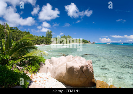 Anse Sévère, La Digue, Seychellen. Blick über die Bucht, Granitfelsen im Vordergrund. Stockfoto