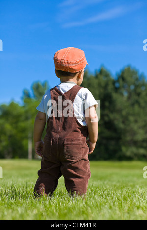 Kleinkind mit Overall Gras gehen. Stockfoto