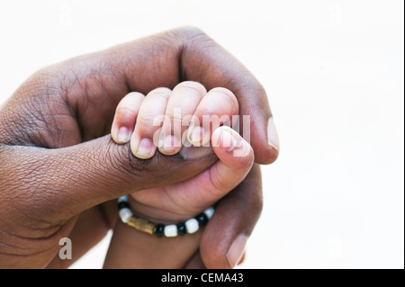 Indische mans Hand hielt seine Hand Neugeborene vor einem weißen Hintergrund. Andhra Pradesh, Indien Stockfoto