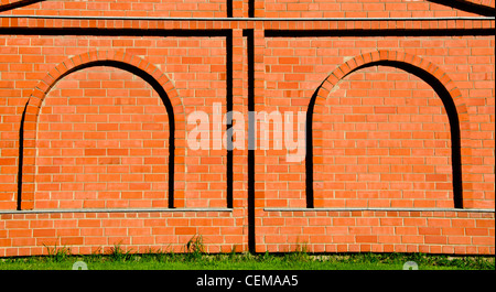 Hintergrund der dekorativen roten Backsteinmauer mit Bogen Imitation. Stockfoto