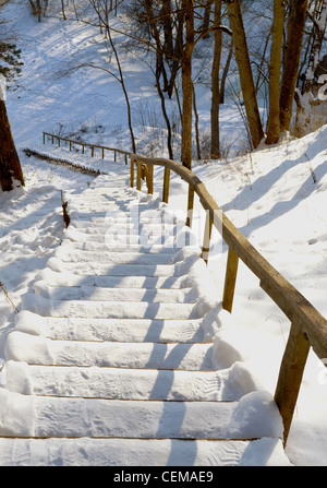 Eiche Treppen und Geländer am steilen Berghang, die im Winter mit Schnee bedeckt. Stockfoto