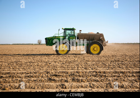 Ein John Deere 4920 mit einem neuen Führer Spreader gilt trocken Dünger enthält Phosphor und Kalium zu einem Bett Feld. Stockfoto