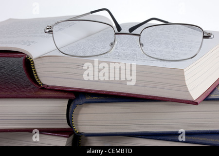 Ein paar der Lesebrille auf einem Haufen alter Leder gebundene Bücher Stockfoto