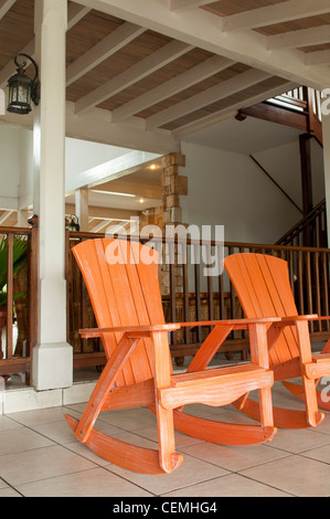 Orange hölzernen Schaukelstühle auf einer Veranda (übliche Einstellung auf einem tropischen Resort) Stockfoto