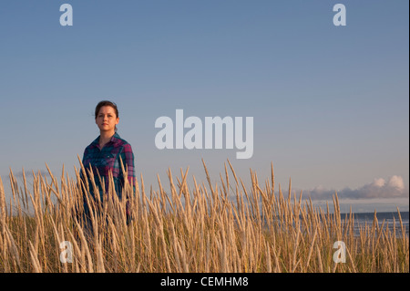 Junge Frau im hohen Grass Sonnenuntergang Porträt Stockfoto