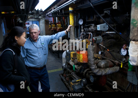Von innen mit KWK-Anlage, einem dicht gepackten Labyrinth von Rohren und schweres Gerät, dass das Gas turbine Combustion Turbine Generator Set beinhaltet, eine effiziente Art der Herstellung von elektrischer und thermischer Energie macht der Mit-Campus zu helfen, während die Verbesserung der Energieeffizienz um 18 % und die Emissionen um 45% gegenüber dem Vorjahr. Stockfoto