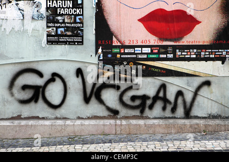 "Go Vegan" Graffiti mit Pop-Art Stil Poster (rote Lippen) auf alten Mauer in zentral-Lissabon, Portugal Stockfoto