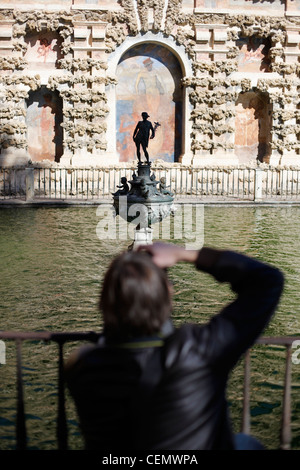 Ein junger Mann nimmt ein Foto im Alcazar Gärten in Sevilla Stockfoto