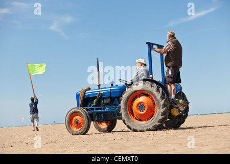 Land Segelregatta, die Beamten fahren einen Traktor am Strand mit Fahnen, die Vorbereitung auf ein Rennen Stockfoto