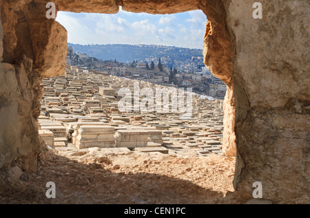 Ein Blick auf jüdische Grabsteine durch ein Loch in der Wand auf dem Ölberg. Stockfoto