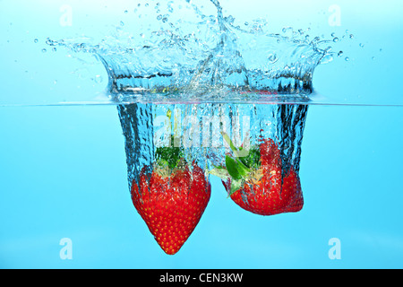 Erdbeeren, sank im Wasser verursacht einen Spritzer Stockfoto