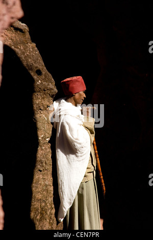 Priester am Eingang zum Haus von Gabriel und Rafael, einer der süd-östlichen Gruppe von Felsen gehauene Kirchen von Lalibela, Äthiopien Stockfoto