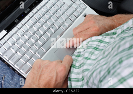 Ein Mann auf einem Laptop eingeben Stockfoto