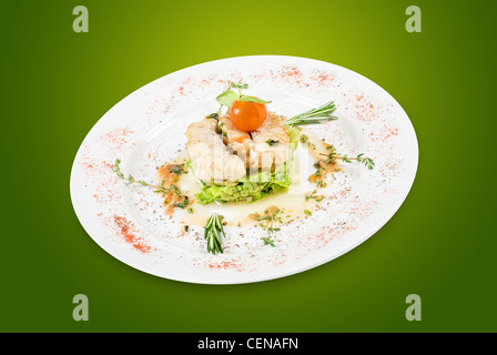 Salat von gebratenen Filet Zander mit Zucchini und Auberginen und Kirschtomaten auf grünem Hintergrund Stockfoto