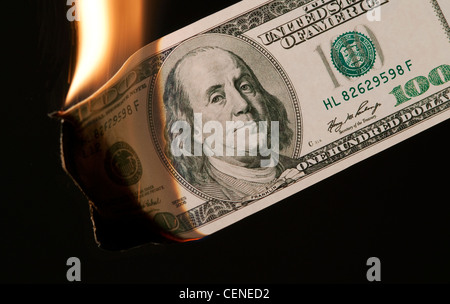 Brennendes Geld US 100 Dollar Rechnung auf schwarzem Hintergrund Stockfoto