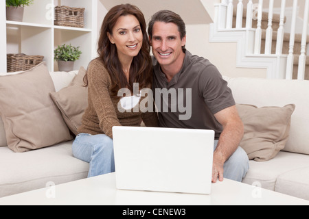 Brautpaar Mann und Frau in den Dreißigern, zusammensitzen zu Hause auf dem Sofa mit einem Laptopcomputer Stockfoto