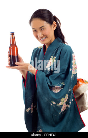 Attraktive lächelnd Kimono-Frau hält eine Flasche Bier, die isoliert auf weißem Hintergrund Stockfoto