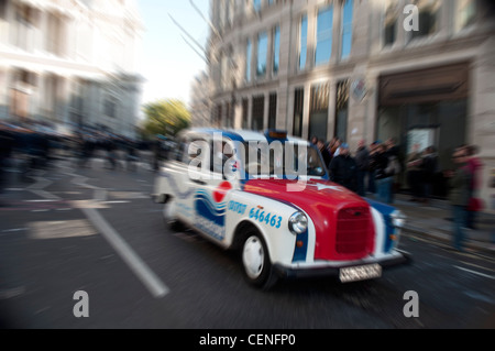 London Taxi bei Geschwindigkeit durch die Straßen der Stadt in der Nähe von St. Pauls Cathedral Stockfoto