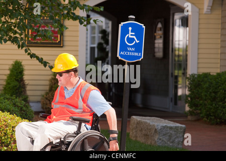 Projektingenieur im Rollstuhl am zugänglichen Parkplatz Stockfoto