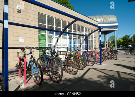 Fahrräder sicher abgestellt in einem Fahrradunterstand vor einem Bahnhof in England. Stockfoto