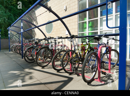 Fahrräder sicher abgestellt in einem Fahrradunterstand vor einem Bahnhof in England. Stockfoto