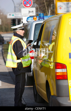 Polizeikontrolle, Verkehr Drehzahlregelung, Polizist stoppt Autos auf einer Straße. Stockfoto