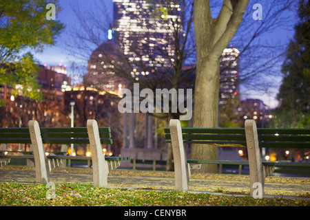 Parkbank mit Gebäude leuchtet in der Dämmerung, Boston, Massachusetts, USA Stockfoto