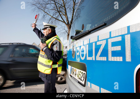 Polizeikontrolle, Verkehr Drehzahlregelung, Polizist stoppt Autos auf einer Straße. Stockfoto