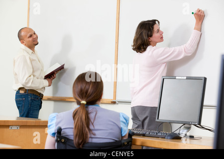 -Studenten präsentieren am Whiteboard im Klassenzimmer Stockfoto