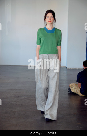 TSE New York bereit zum tragen Spring Summer Green Jumper über blauen Oberteil und graue Hosen Stockfoto