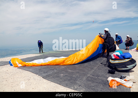 Paragleiter vom Gipfel des Tegelberg in Schwangau in Bayern, Deutschland, warten auf geeignete Windverhältnisse Take-off bereit Stockfoto