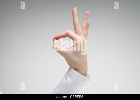 Frau zeigt Ok Handsymbol auf hellem Hintergrund Stockfoto