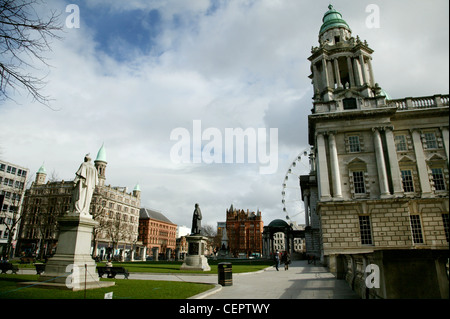 Statuen auf der Vorderseite der Belfast City Hall mit dem Belfast-Rad im Hintergrund. Stockfoto