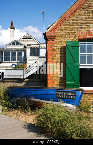 Ein kleines Boot, Whitstable Oyster Company vor ihrem Restaurant direkt am Meer in Whitstable angehören. Stockfoto