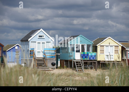 Ein Blick durch lange Grashalme in Richtung Strandhütten am Strand von Mudeford, zwei Meilen von Christchurch. Stockfoto