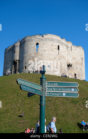 Clifford es Tower, einer der wichtigsten Überreste des York Castle mit einem touristischen Wegweiser im Vordergrund. Stockfoto