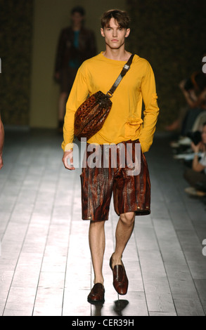 Fendi Menswear bereit zu tragen-Frühling-Sommer-Modell dunkelbraune Haare tragen leuchtend gelbe Spitze und Knie Länge glänzend braun und Stockfoto