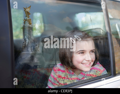 Ein junges Mädchen aus einem Autofenster im Buckingham Palace. Stockfoto