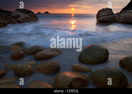 Sonnenuntergang über dem Meer gesehen von Porth Nanven, einem Strand, manchmal auch als "Dinosaurier-Ei-Beach" wegen großen Kaution in Höhe von Stockfoto