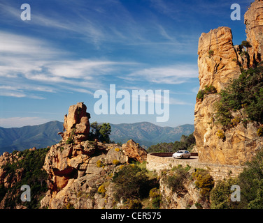 Auto auf der Straße durch Les Calanche, in der Nähe von Porto, Corse-du-Sud, Korsika, Frankreich. Ein UNESCO-Weltkulturerbe. Stockfoto