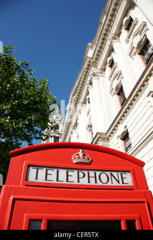 Eine traditionelle rote Telefon-Box-Set vor einem blauen Himmel in London. Stockfoto