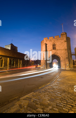 Der Westgate Tower in Canterbury beleuchtet in der Nacht mit Studien des Lichts vom Durchgangsverkehr. Stockfoto