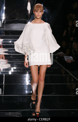 Blondes Frauen Modell trägt einen kurzen weißen Kleid Scoopneck und Glocke geprägt Fackel Rüsche Ärmel getragen schwarze zehenoffenen Pumps Stockfoto